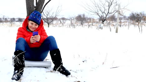 Child-using-smartphone-in-winter-park