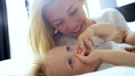 Portrait-of-baby-girl-lying-with-loving-mum