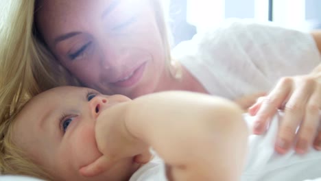 Portrait-of-mother-kissing-baby-daughter-at-home