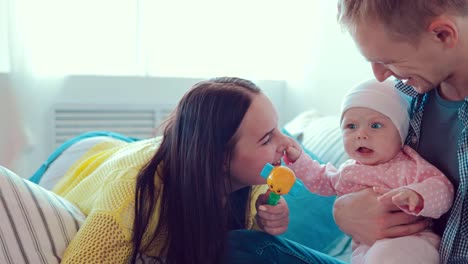 Mamá-besa-al-bebé.-El-niño-sienta-sobre-sus-rodillas,-su-padre