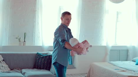 Dad-que-a-un-niño-pequeño-en-sus-brazos-en-una-habitación