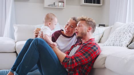 Junge-weiße-paar-Sit-spielen-mit-Baby-zu-Hause,-Seitenansicht