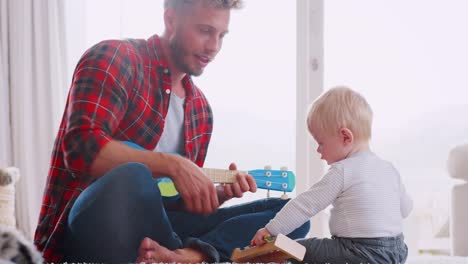 Dad-and-toddler-son-playing-with-instruments,-close-up