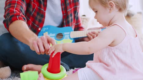 Joven-papá-jugando-con-su-hija-para-niños-pequeños-en-casa,-de-cerca