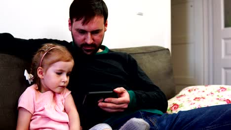 Daughter-and-father-look-into-the-smartphone-and-discuss-what-they-saw