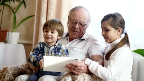 Abuelo-usando-un-Tablet-PC-con-nietos