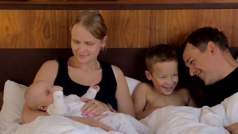 Family-of-four-together-in-bed-at-home