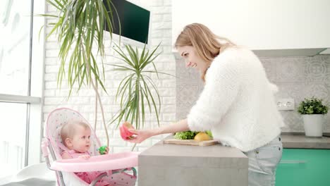 Mujer-bonita-cocina-comida-sana-con-el-bebé.-Dieta-saludable