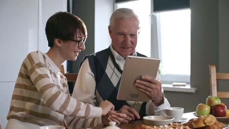 Granddaughter-Helping-Grandfather-with-Tablet