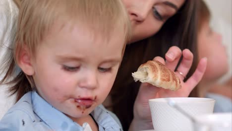 Lindo-bebé-niño-comer-croissant-de-chocolate