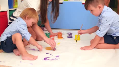 Joven-madre-enseña-a-sus-hijos-pequeños-a-pintar-el-sol