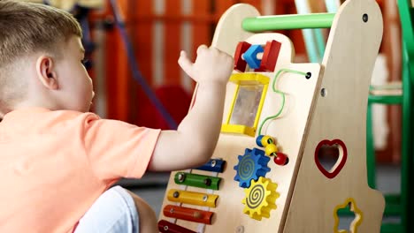 A-little-boy-in-a-kindergarten-plays-a-developing-toy