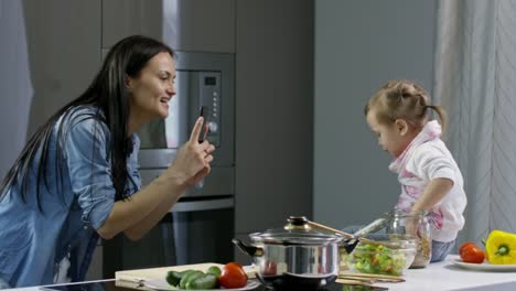 Madre-toma-foto-de-niño-en-la-mesa-de-la-cocina