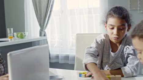 Niños-jugando-junto-a-madre-ocupado-trabajando-desde-casa