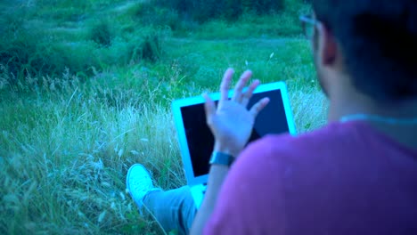 Close-up,-Reflection-in-the-Laptop-Screen,-Indian-Male-Emotionally-Talking-on-the-Phone-Kneeling-Laptop-Sitting-In-the-Evening-on-the-Grass-at-Summit-Hill