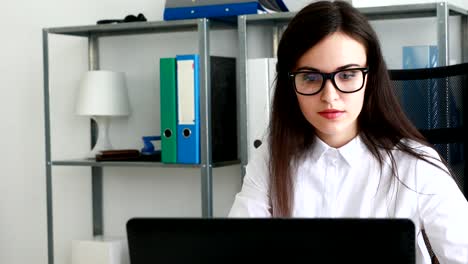 geschäftsfrau-startende-schwarze-Brillen-und-stützen-Kopf-mit-Hand-im-modernen-Büro