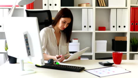 geschäftsfrau-im-Bürostuhl-sitzen-und-in-Dokumenten-suchen