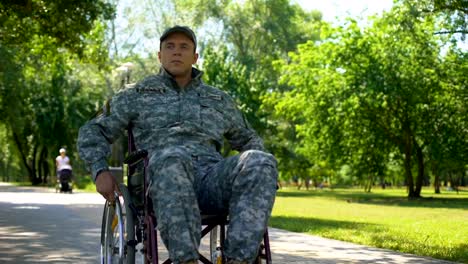 American-military-veteran-moving-on-wheelchair-in-city-park,-health-care-program