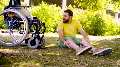 Happy-young-disable-man-sitting-on-the-grass-in-the-park