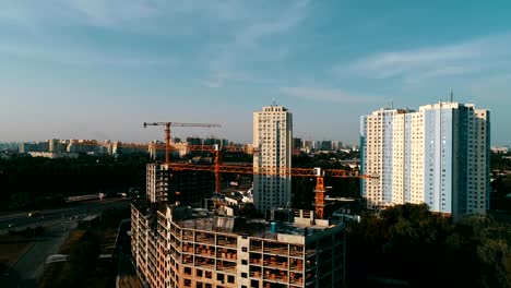 the-construction-crane-and-the-building-against-the-blue-sky