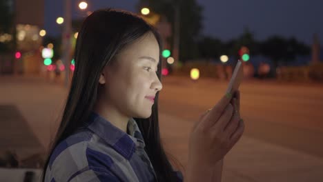 Young-Asian-woman-using-tablet-in-the-city-streets