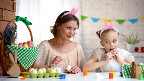 Unfug-Mädchen-essen-Schokolade-Ei-bis-Mutter-sieht,-Kindheit,-Ostern-Vorbereitung