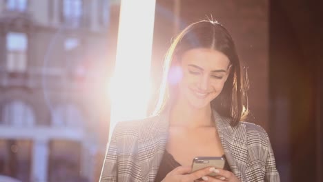 Mujer-de-negocios-hermosa-usando-teléfono-móvil-al-aire-libre-en-día-soleado