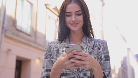 Beautiful-Woman-Using-Mobile-Phone-On-Street