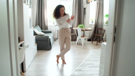 Encantadora-mujer-joven-usando-el-teléfono-en-moderno-apartamento-elegante.