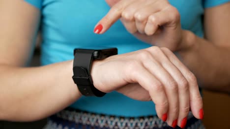 Mujer-utilizando-su-dispositivo-de-smartwatch-pantalla-táctil-tecnología-usable.-Chica-haciendo-gestos-en-un-portátil-inteligente-ver-dispositivo-de-computadora,-cerrar.