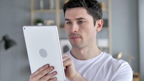 Young-Man-Using-Tablet-at-Workplace