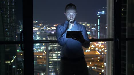 Young-man-using-tablet-to-speak-and-communicate-with-skyscraper-view-background