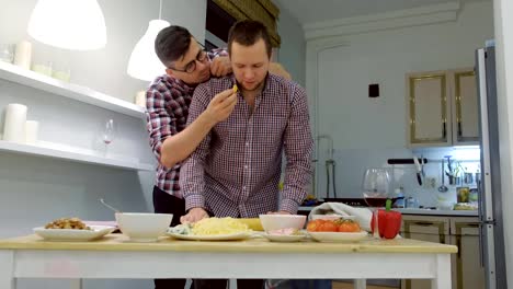 Couple-of-men-gay-roll-out-the-pizza-dough-together-hugging.