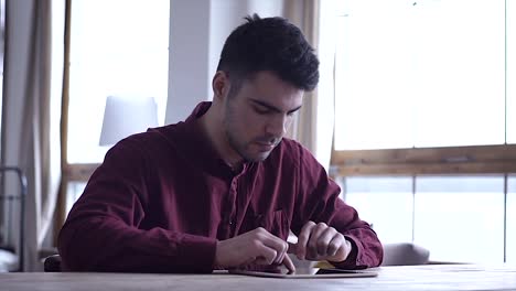 Close-up:-the-use-of-the-tablet.-A-man-at-a-business-meeting-uses-a-Tablet.-Modern-technologies.-Unknown-man-holding-a-finger-on-the-touch-screen-of-the-tablet.