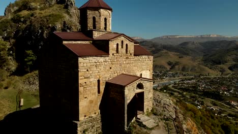 vista-aérea-4K-UHD-de-un-monasterio-de-montaña-de-pie-sobre-un-acantilado