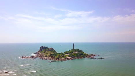 Aerial-view-lighthouse-on-rocky-island-in-blue-sea-landscape.-Drone-view-light-house-on-cliff-in-ocean-on-blue-sky-background