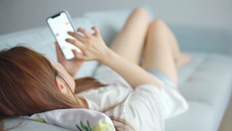 Asian-woman-using-cellphone-in-living-room