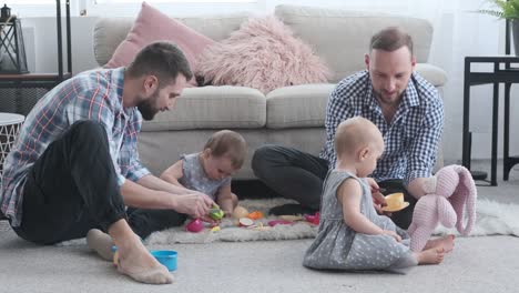 Two-dads-and-baby-daughter-playing-with-toy-at-home