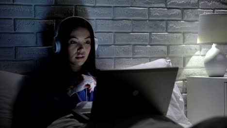 Girl-abruptly-removing-headphones,-afraid-of-sudden-loud-advertising-on-internet