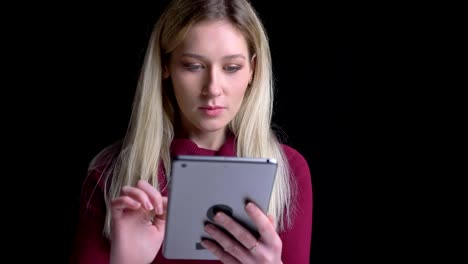 Closeup-portrait-of-young-pretty-caucasian-female-using-the-tablet-getting-excited-and-surprised-while-looking-at-camera