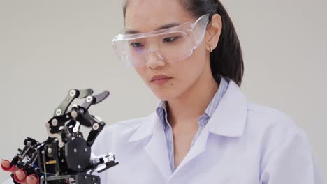 Asian-woman-testing-cyborg-hand-at-lab.