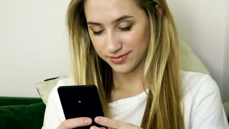 Joven-mujer-sonriente-usando-el-teléfono-inteligente,-enviando-mensajes-de-texto-en-el-teléfono-móvil-en-la-cafetería-moderna.-4K