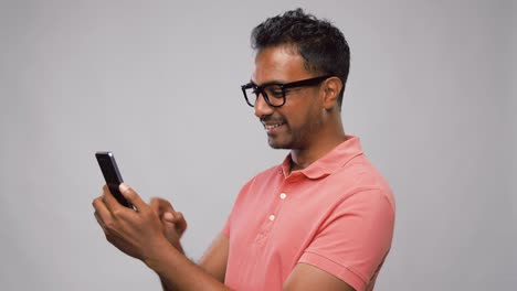 hombre-indio-feliz-en-gafas-usando-teléfono-inteligente