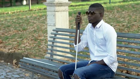 Blind-young-american-african-man-sitting-on-bench.Independance,disability