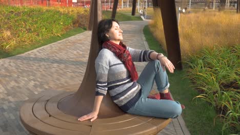 Caucasian-woman-sitting-on-a-park-bench-closed-her-eyes