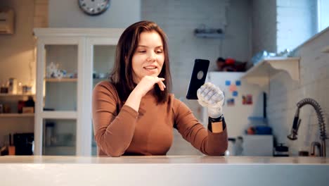 Behinderte-Frau-hält-ein-Telefon-mit-einer-Prothese,-aus-nächster-Nähe.