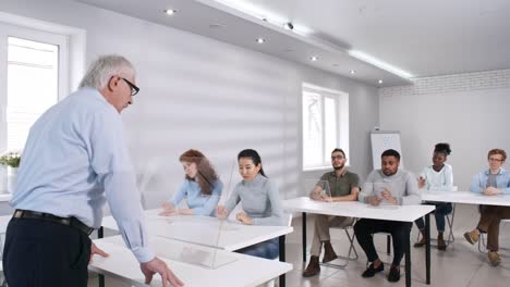 Senior-Male-Teacher-Tapping-en-la-pantalla-táctil-interactiva-de-AR-en-clase