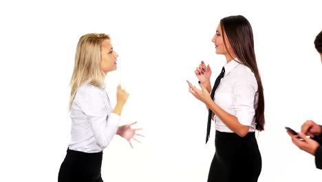 Two-female-colleagues-talking-when-a-male-colleague-with-a-smart-phone-passes-by