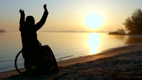 Sonnenuntergang-Hände-hoch-auf-Rollstuhl,-einsam-auf-Rollstuhl,-männliche-deaktiviert