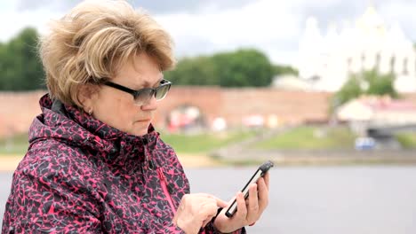 Mujer-vestida-con-chaqueta-de-deporte,-sosteniendo-teléfono-móvil